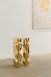 Mimo est une table d’appoint en laiton poli miroir, non verni. Sa structure repose sur une intention formelle simple : trois pieds et un plateau. Ses pieds, formés de manière organique, contrastent avec la ligne fine et délicate de son plateau.

La surface polie capte la lumière et reflète l’environnement, révélant l’élégance contenue dans la simplicité. Le laiton, travaillé à la main, invite à une expérience sensorielle où la matière et l’espace entrent en conversation.