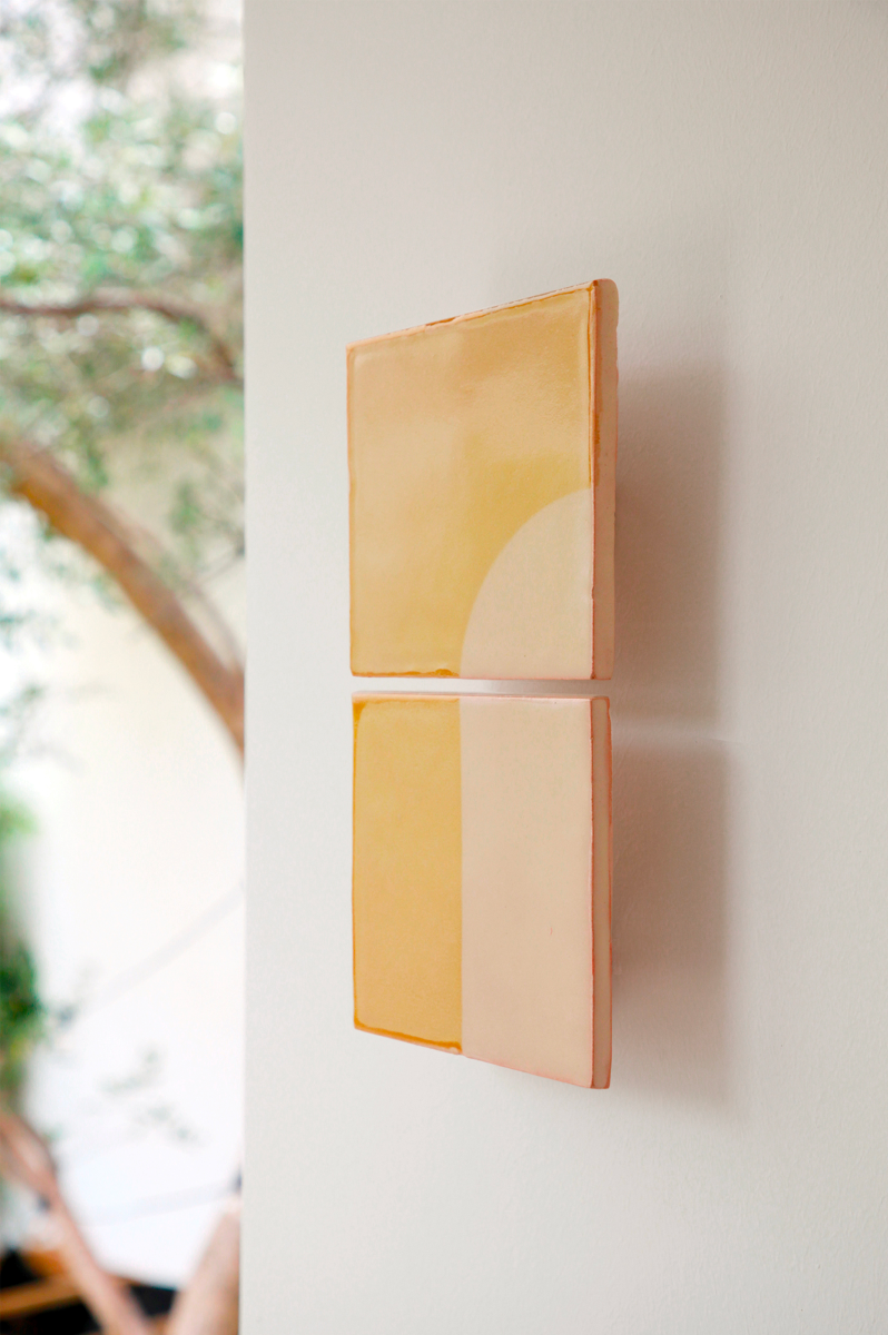 Les tuiles sont teintées dans des coloris naturels en utilisant le procédé de la sérigraphie. La Tiles J est ainsi colorée d'un jaune clair et d'un beige représentant la céramique brute. L'ampoule, cachée derrière un carreau, diffuse un éclairage indirect, créant un effet de clair-obscur et un éclairage très doux. Les tuiles sont composées de deux carrés de céramique et peuvent être utilisées seules ou combinées pour former des motifs plus complexes.