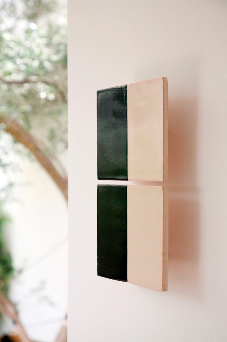 Les Tiles sont des appliques murales réalisées par Violaine d'Harcourt en collaboration avec la designer hollandaise Marianne Smink. Utilisant le procédé de la sérigraphie, l'appliqué Tiles G est ainsi coloré d'un noir et d'un beige représentant la céramique brute. L'ampoule, cachée derrière un carreau, diffuse un éclairage indirect, créant un effet de clair-obscur et un éclairage très doux.