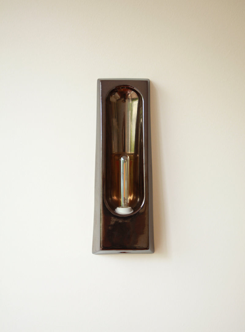 Alliance de l'artisanat et du design contemporain, les appliques Alcove de Violaine d'Harcourt sont fabriquées en céramique émaillée au Portugal, dans une région où le travail de l'argile est une tradition ancestrale. Leur forme s'inspire de l'élément architectural auquel elles ont emprunté leur nom - l'alcôve - qui évoque une ambiance intimiste et feutrée. Au centre de l'applique, une élégante ampoule tubulaire diffuse une lumière tamisée qui sublime les émaux aux teintes naturelles.&nbsp;