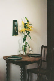 Alliance de l'artisanat et du design contemporain, les appliques Alcove de Violaine d'Harcourt sont fabriquées en céramique émaillée au Portugal, dans une région où le travail de l'argile est une tradition ancestrale. Leur forme s'inspire de l'élément architectural auquel elles ont emprunté leur nom - l'alcôve - qui évoque une ambiance intimiste et feutrée. Au centre de l'applique, une élégante ampoule tubulaire diffuse une lumière tamisée qui sublime les émaux aux teintes naturelles.