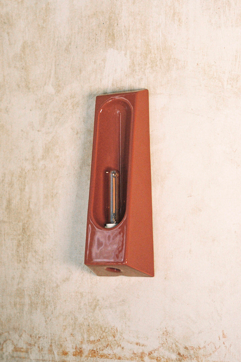 Alliance de l'artisanat et du design contemporain, les appliques Alcove de Violaine d'Harcourt sont fabriquées en céramique émaillée au Portugal, dans une région où le travail de l'argile est une tradition ancestrale. Leur forme s'inspire de l'élément architectural auquel elles ont emprunté leur nom - l'alcôve - qui évoque une ambiance intimiste et feutrée. Au centre de l'applique, une élégante ampoule tubulaire diffuse une lumière tamisée qui sublime les émaux aux teintes naturelles.&nbsp;