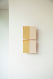 Les Tiles sont des appliques murales conçues par Violaine d'Harcourt en collaboration avec la designer hollandaise Marianne Smink. Utilisant le procédé de la sérigraphie, l'applique Tiles G est ainsi colorée d'un jaune et d'un beige représentant la céramique brute. L'ampoule, cachée derrière un carreau, diffuse un éclairage indirect, créant un effet de clair-obscur et un éclairage très doux.