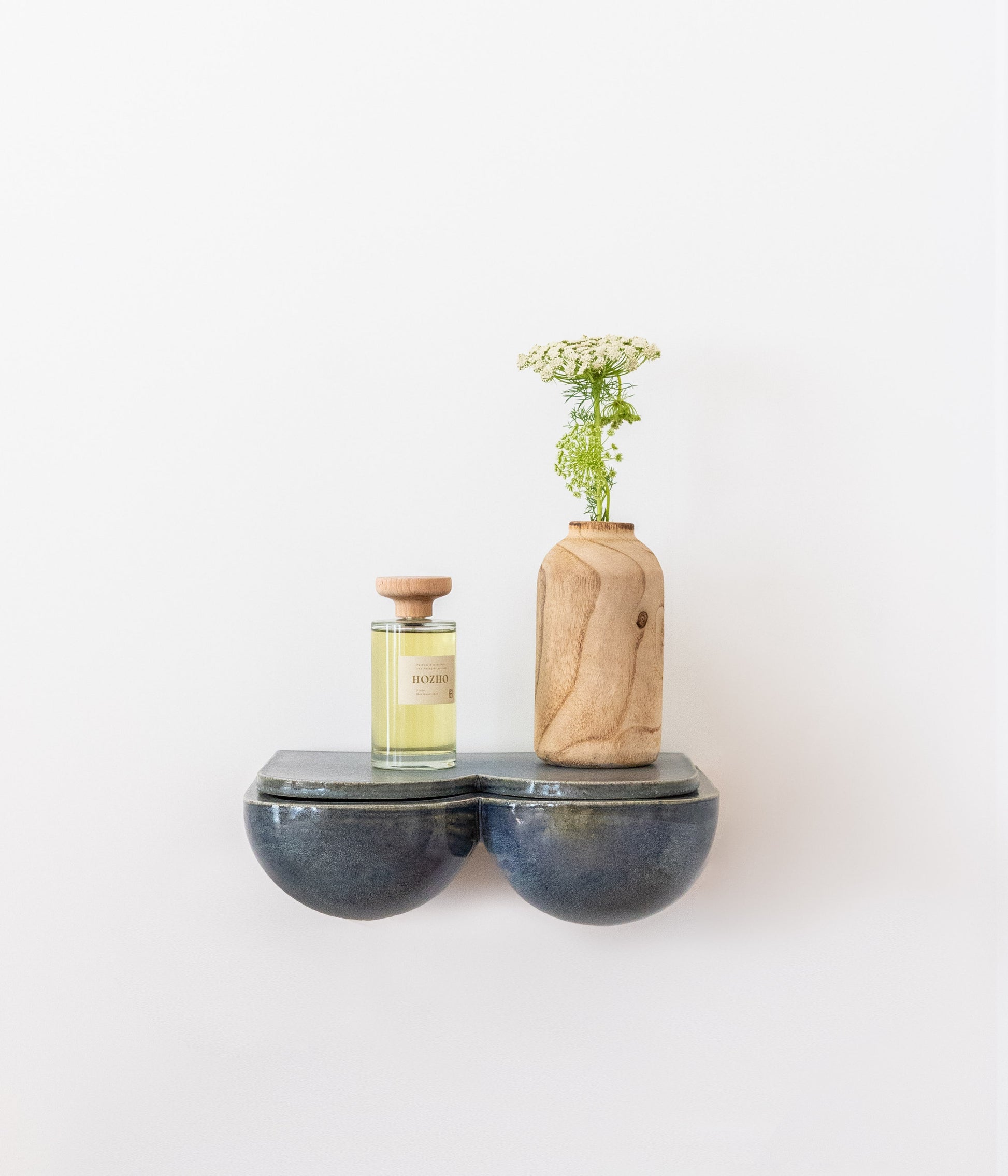 L'étagère, véritable pièce créative, aux lignes harmonieuses et généreuses saura habiller votre mur. En table de chevet ou dans votre entrée, en solo, duo ou trio... les combinaisons sont nombreuses et donnent libre cours à votre imagination. Ses rondeurs et son émail brillant couleur bleu lazuli lui donnent une allure douce et des airs de bijou artisanal. &nbsp;  Petite subtilité, une niche se cache sous la tablette amovible et fera office de rangement pour vos trésors, apportant une double.