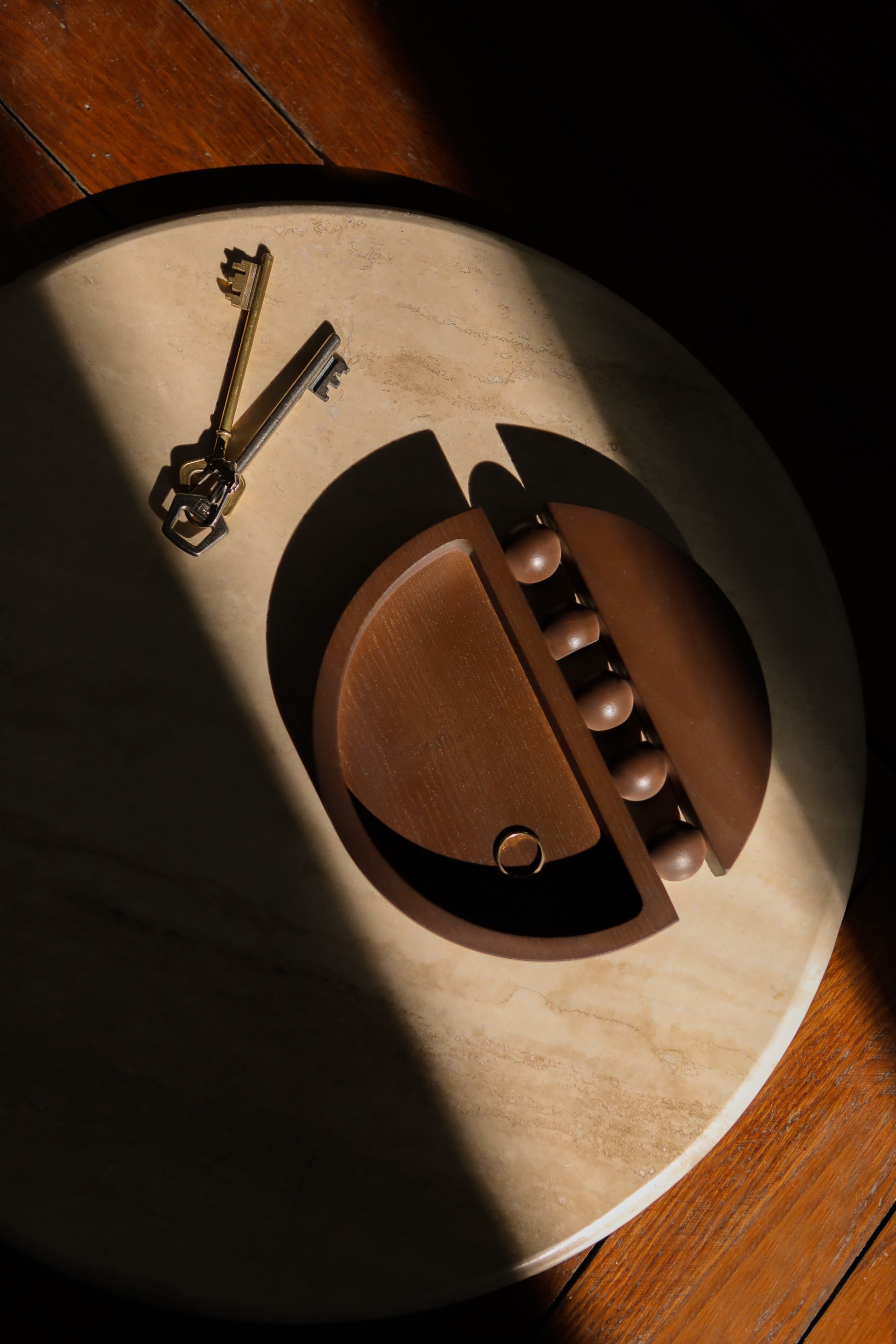 En décoration d’intérieur, il y a des petits objets qui font la différence ! C’est le cas du vide poche Tolitoli réalisé en frêne teinté noyer. Sur une console dans l’entrée pour y déposer ses clés, ou sur une table basse pour ranger ses trésors, sa forme tout en rondeur entrecoupée de cette ligne de sphères emblématique de notre première collection Déranger les Courbes lui donne beaucoup de personnalité. Tout comme notre étagère Leòn, c’est un petit bijou d’ébénisterie.